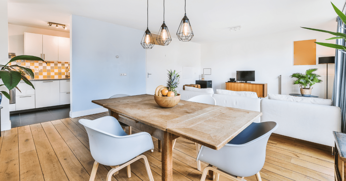 A wooden dining room table with sleek grey chairs.