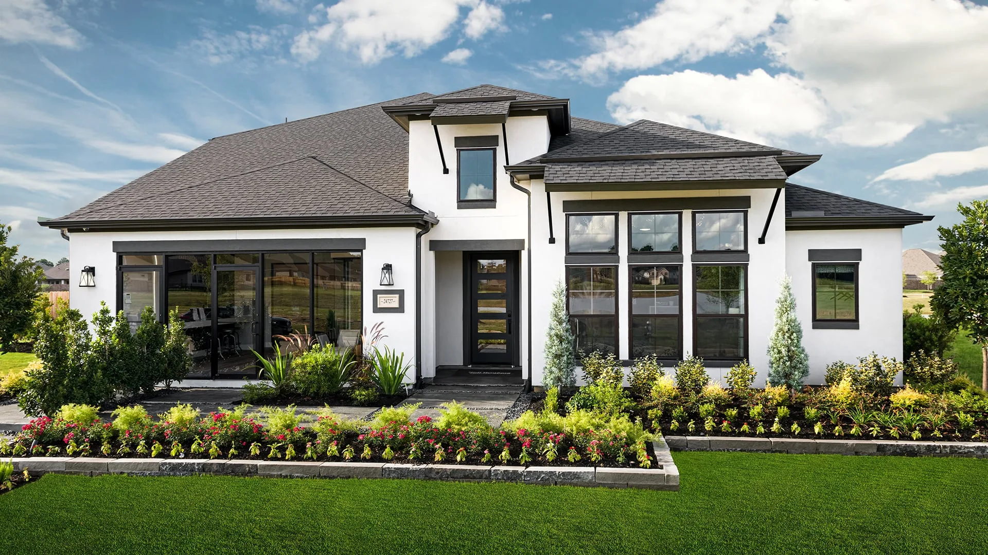 A large white home with black trim and a dark roof.