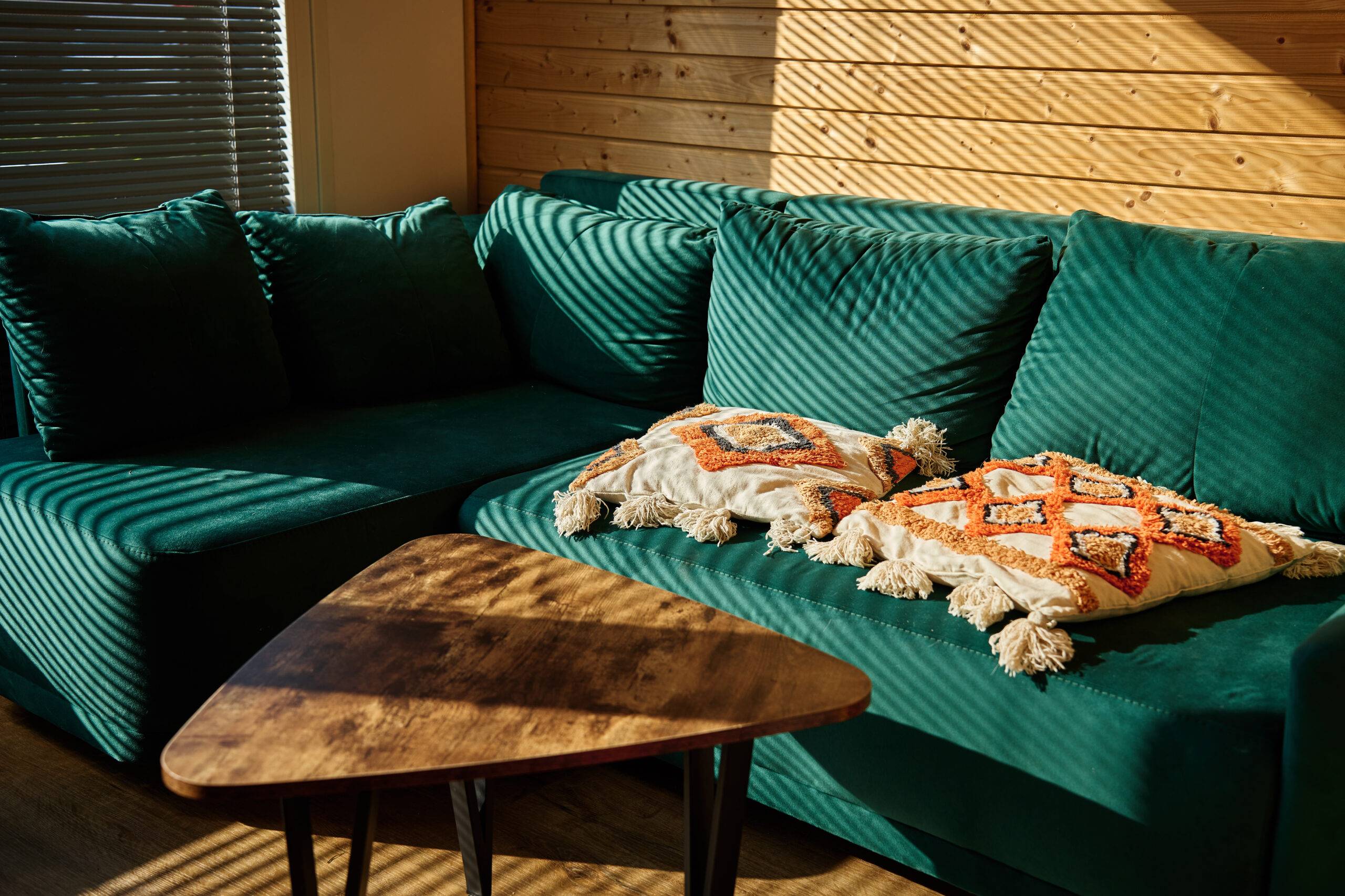 Living room interior with green sofa and coffee table with sunlight. Place for relax at cozy home.