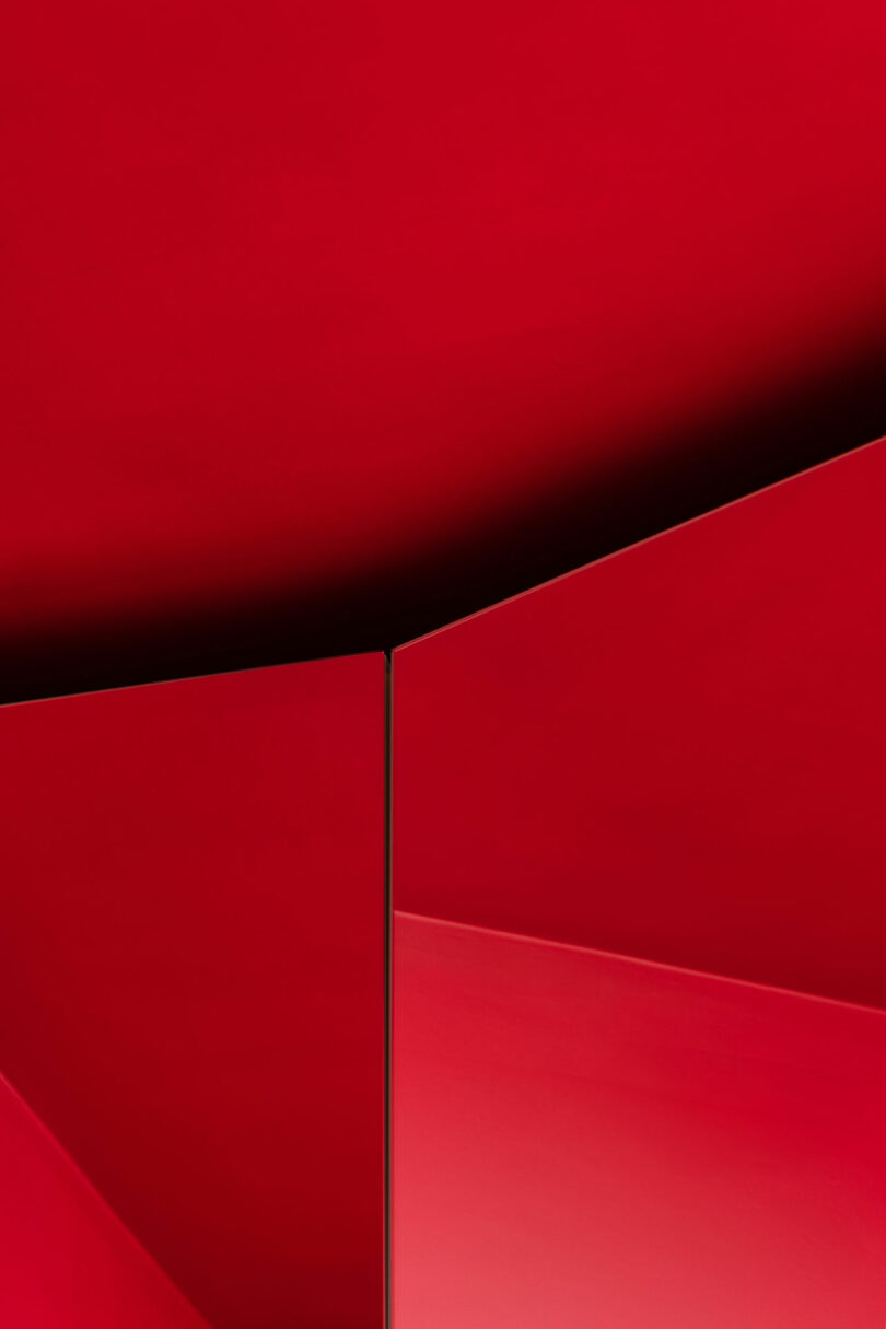 Abstract image featuring overlapping red geometric shapes with sharp lines and shadows.