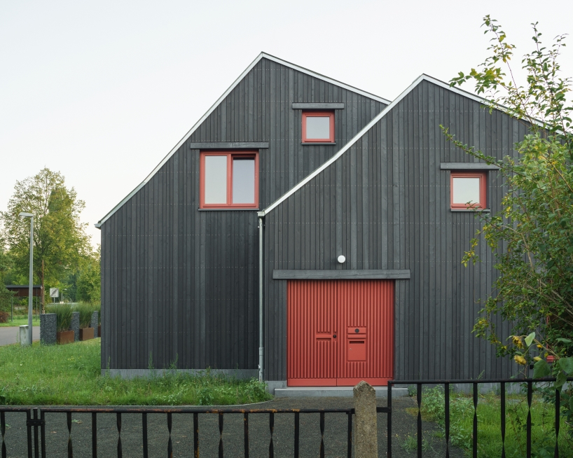 dark wooden facade by ko/ok architektur contrasts semi-detached gabled house in germany