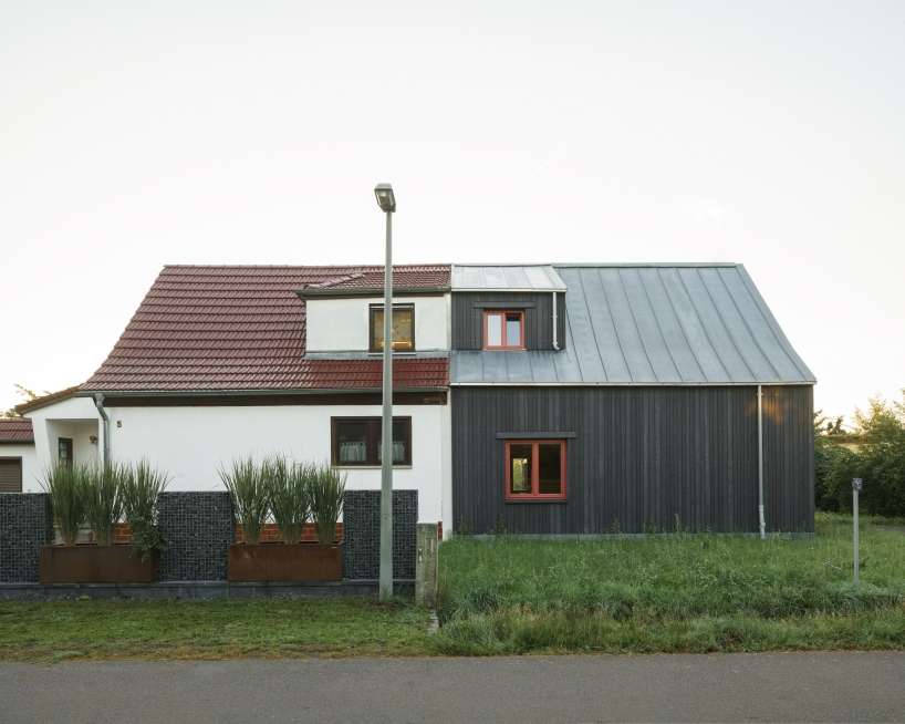 dark wooden facade by ko/ok architektur contrasts semi-detached gabled house in germany