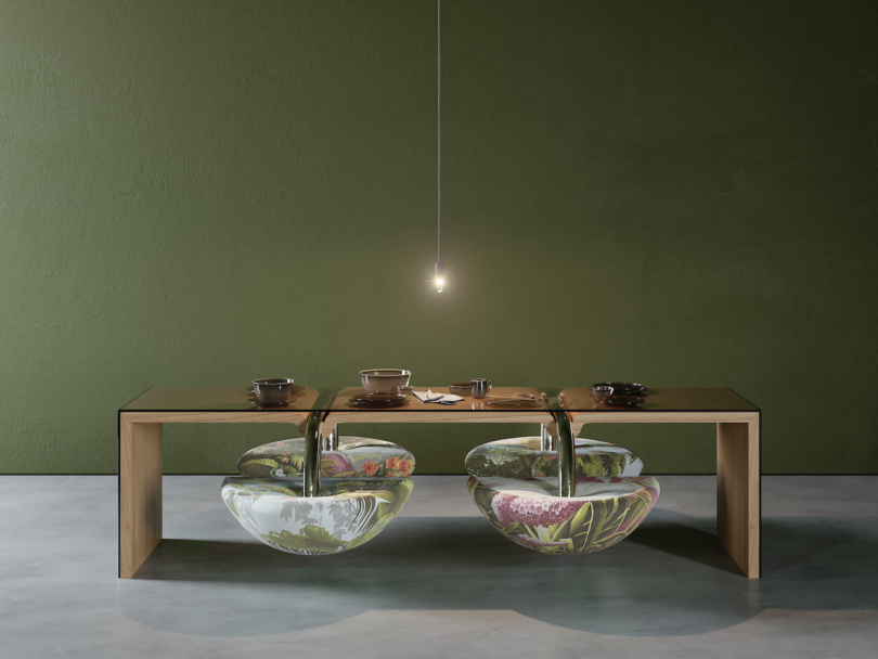 A wooden table with a small hanging light above; two large, clear bowls with floral designs are integrated beneath the tabletop, partially filled with items