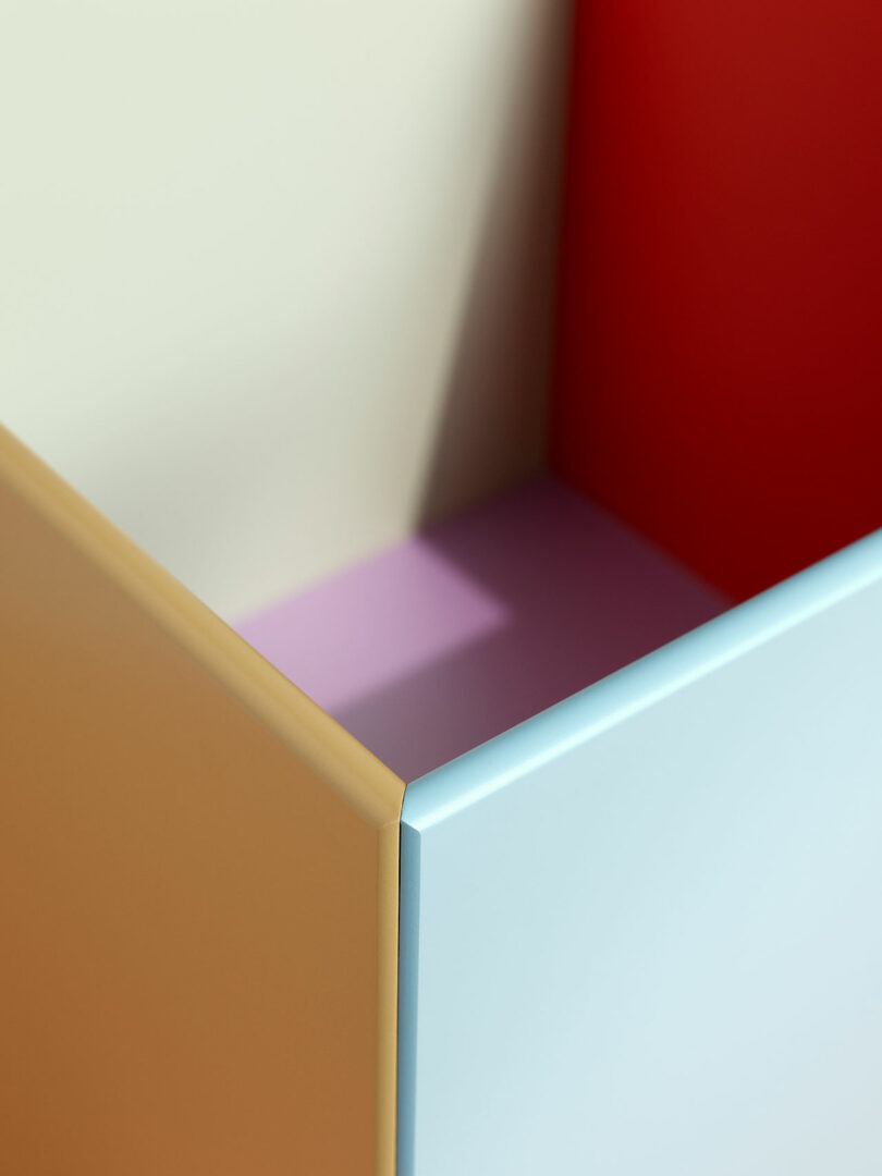 Abstract geometric composition featuring intersecting panels in beige, light blue, red, and purple with sharp angles and smooth surfaces, reminiscent of the contemporary designs found in KIMPOP Montana Furniture collections.