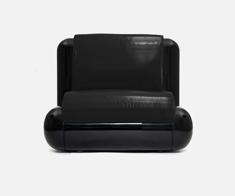 Black, modern-style armchair with a glossy frame and smooth leather upholstery, set against a plain white background.