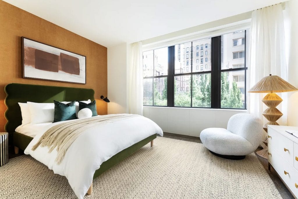 Ochre accent wall in a contemporary bedroom by Decorilla designer, Leanna S.