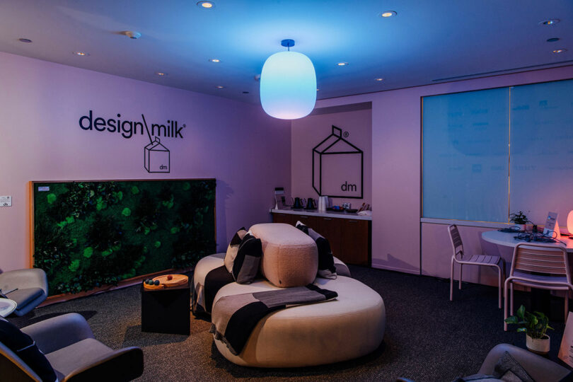 Modern Designer Wellness Lounge featuring a curved white sofa, chic chairs, wall art reading 