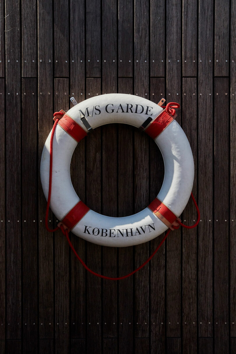 A white lifebuoy with red bands and the text 