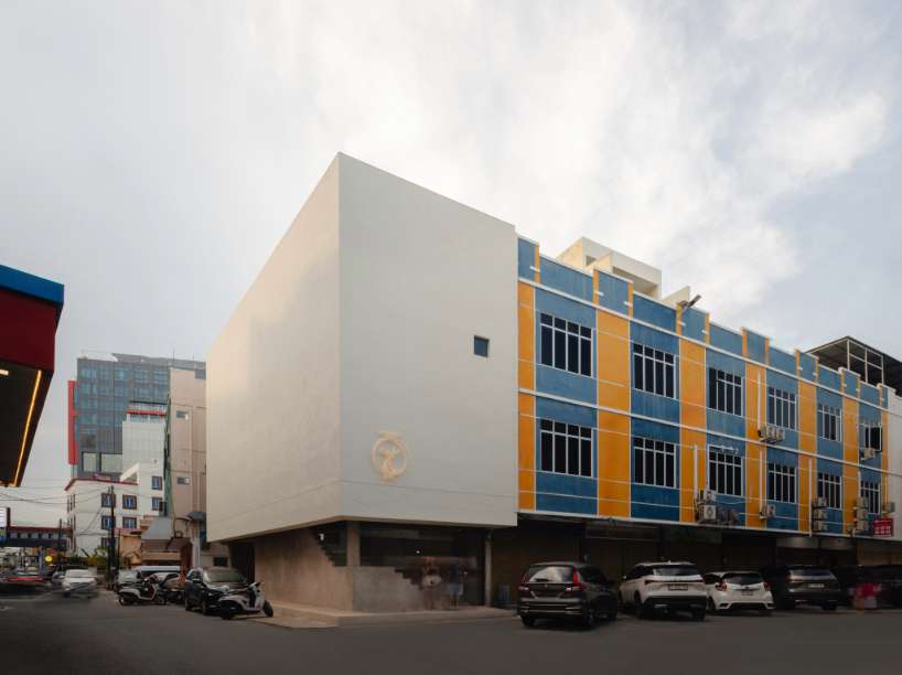dessert shop's white facade contrasts with colorful commercial streetscape in indonesian city