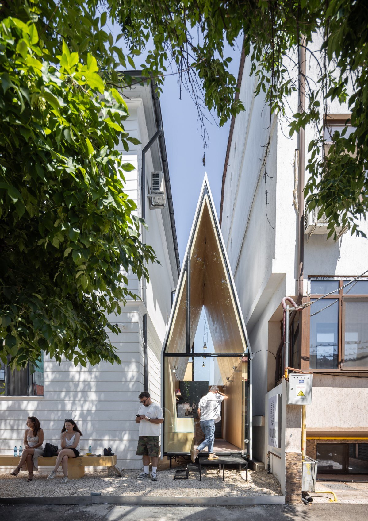 vinklu inserts triangular prism into narrow urban gap for coffee shop in romania