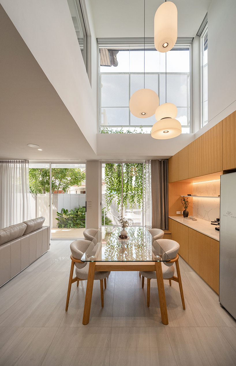 curved textile facades wrap reborn house in bangkok village emitting soft glow