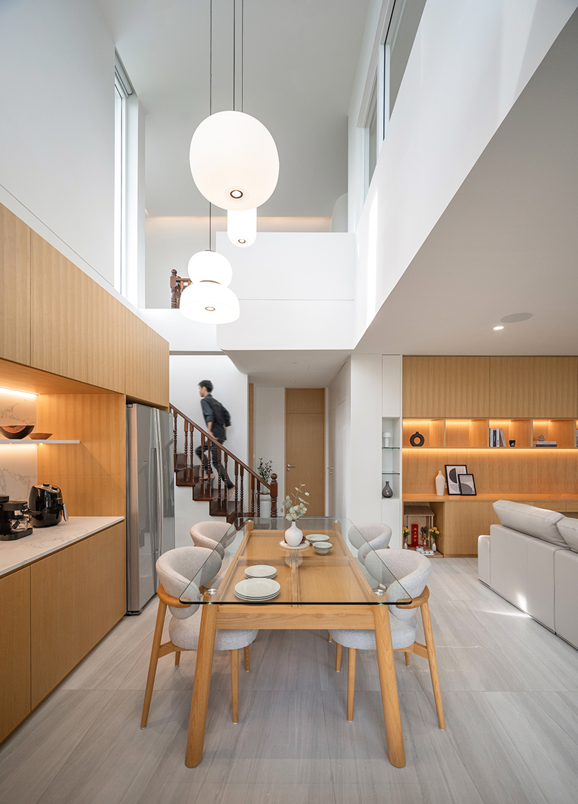 curved textile facades wrap reborn house in bangkok village emitting soft glow