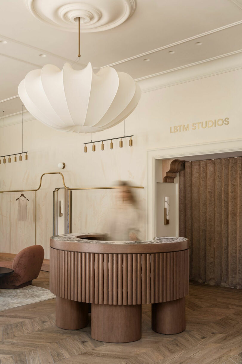A stylish reception area with a wooden desk, modern light fixture, and 