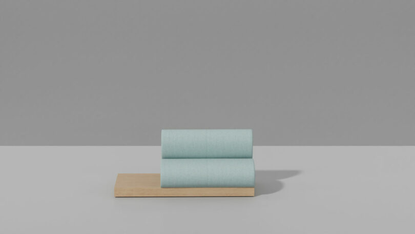 Two light blue cylindrical objects, resembling candy, are stacked horizontally on a rectangular wooden base against a plain grey background.