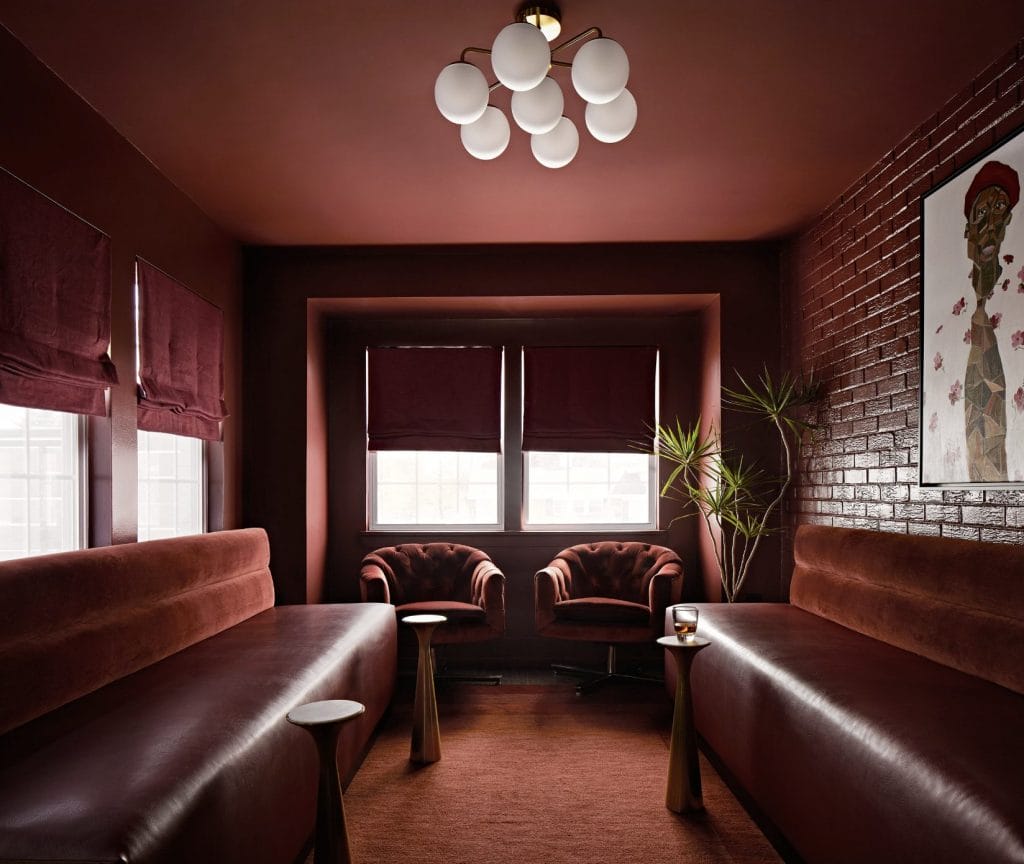 Deep, rich colors and vintage velvet chairs define this dark academia aesthetic by Decorilla designer Dorian R.