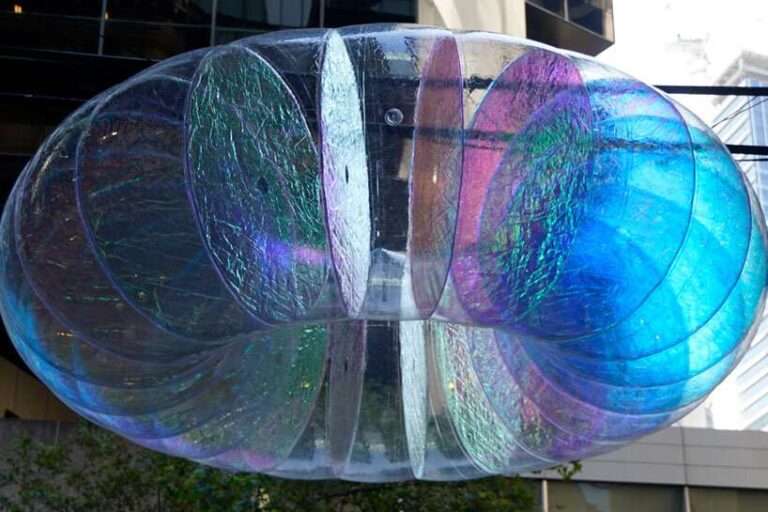 floating oculus installation shimmers in shifting chromatic light above brooklyn’s streets