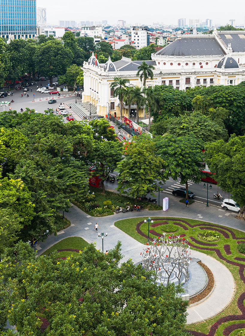 a circle of mirroring steel branches composes a luminous forest in hanoi's public realm