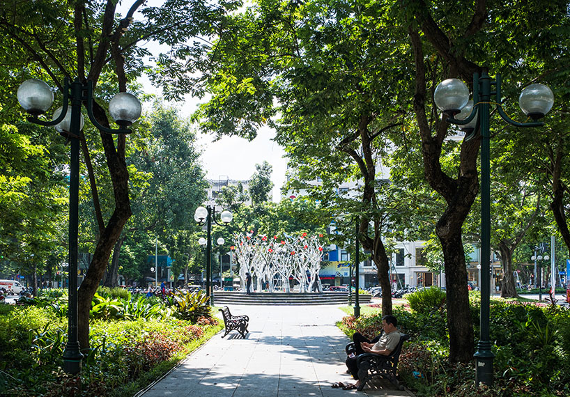 a circle of mirroring steel branches composes a luminous forest in hanoi's public realm