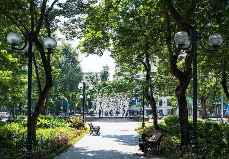 a circle of mirroring steel branches composes a luminous forest in hanoi’s public realm