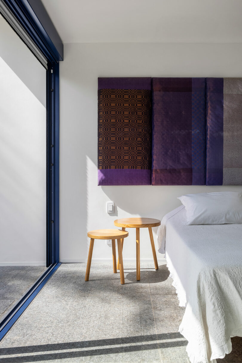 partial interior shot of modern bedroom in white with purple artwork