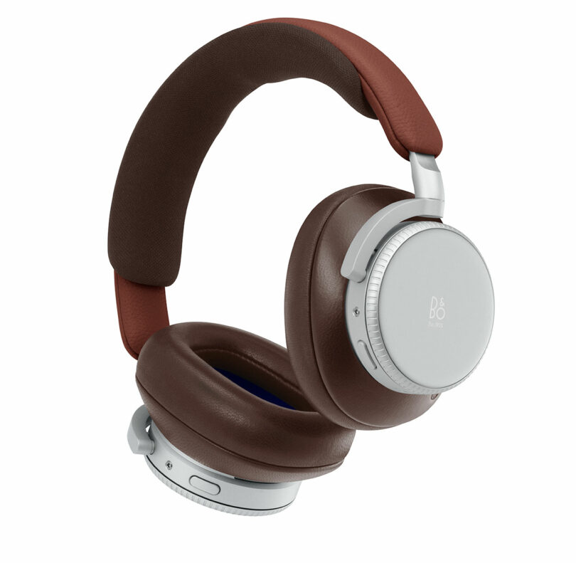 Over-ear wireless headphones with brown cushioned ear pads and headband, silver ear cups, and visible control buttons on the side.
