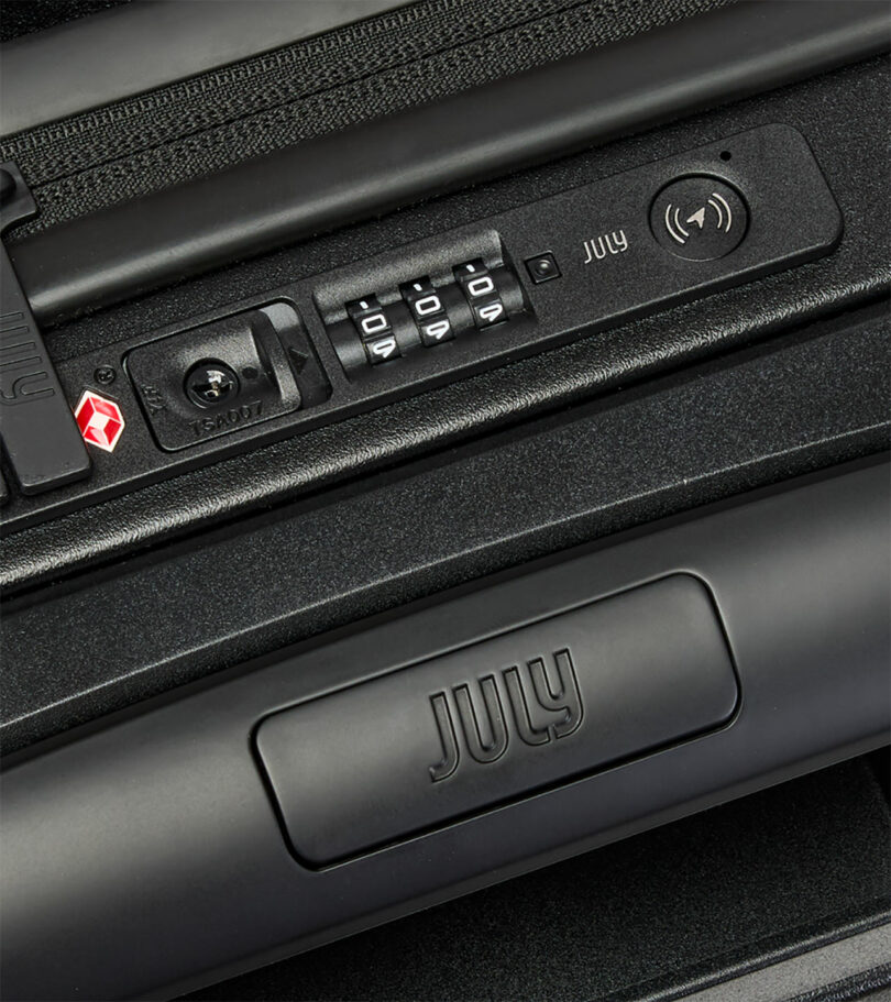 Close-up of a black suitcase showing a TSA-approved lock, a 3-digit combination dial, a USB port, and the brand name 