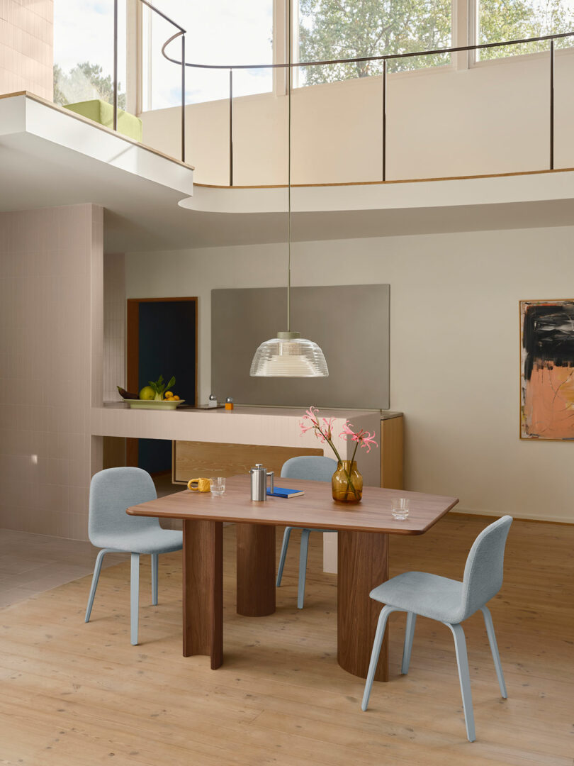 A dining table with chairs in a room with a high ceiling.