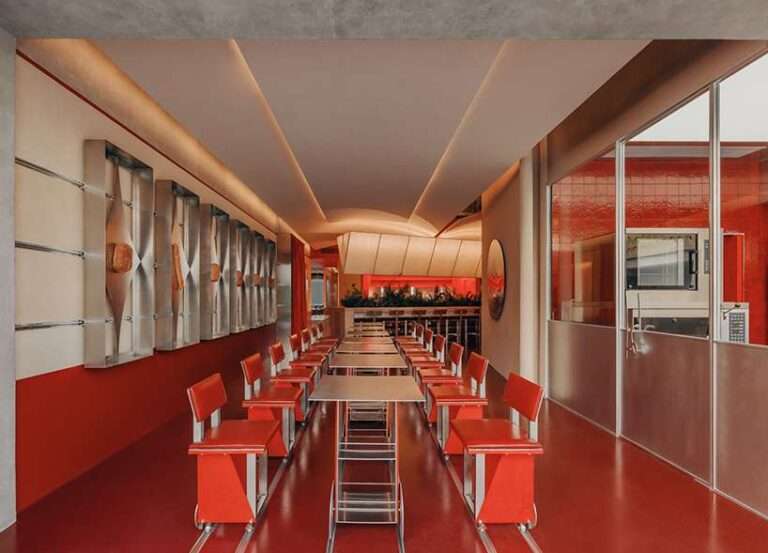 row of circular red panels lines the facade of café on-site by aptdotapt in china