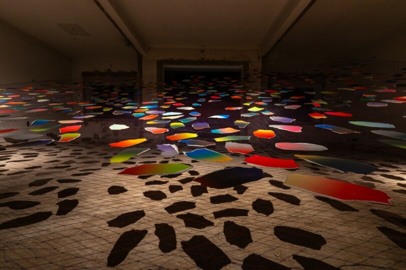 Colorful paper shapes hang from strings indoors,