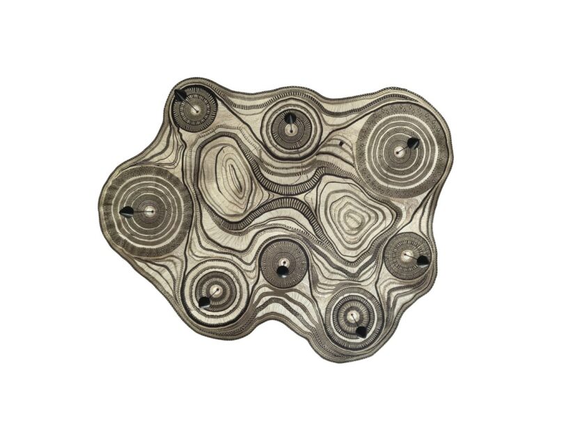 An abstract, irregularly shaped textile-lamp with concentric circular patterns in black and beige on a white background