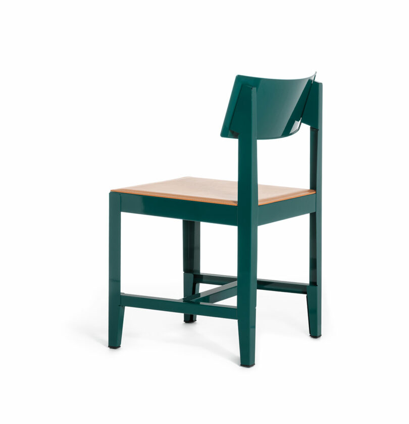 A modern chair with a green metal frame, a wooden seat, and an angled backrest, photographed on a white background.