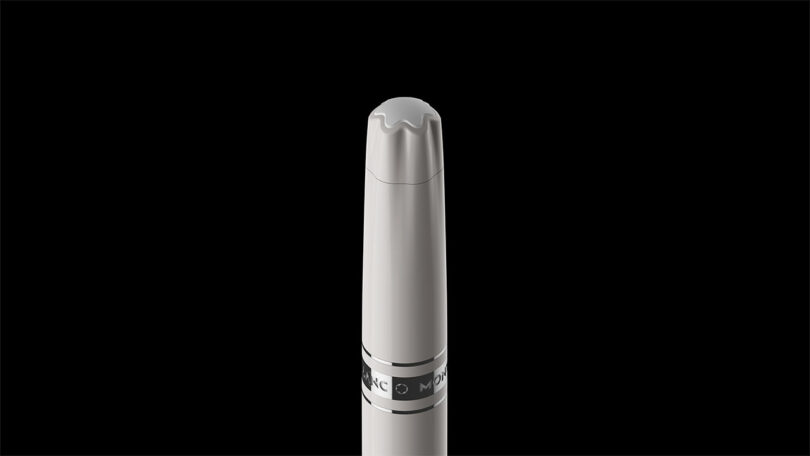 A silver and black marker with a chisel tip, designed by Fuseproject, is shown upright against a plain black background.