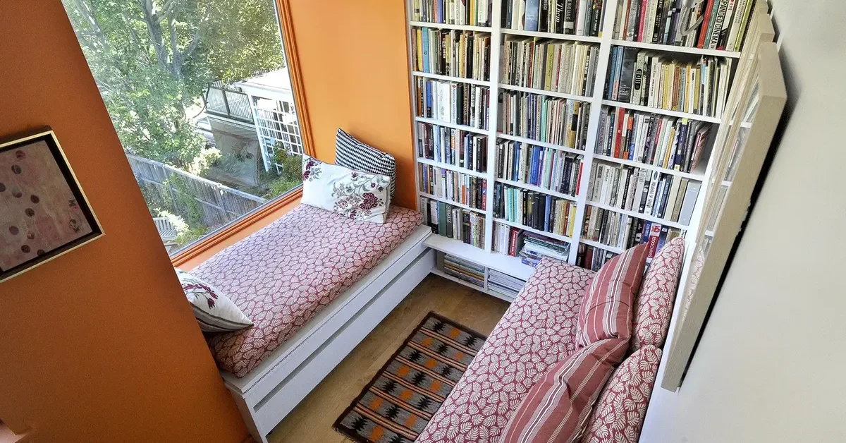a small reading nook with comfotable bench style seating, looking out onto a view.