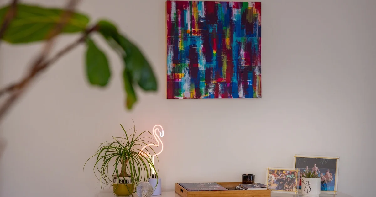 An unframed moder art on a wall in a home.