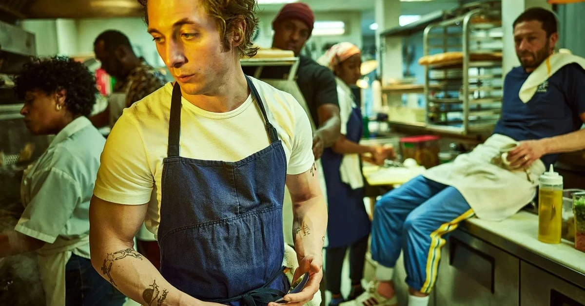 A still from the series where the protagonist is working with others in a restuarant kitchen.