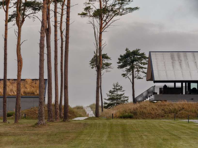 grass-covered seaside family home repurposes abandoned soviet military bunkers in latvia - 1