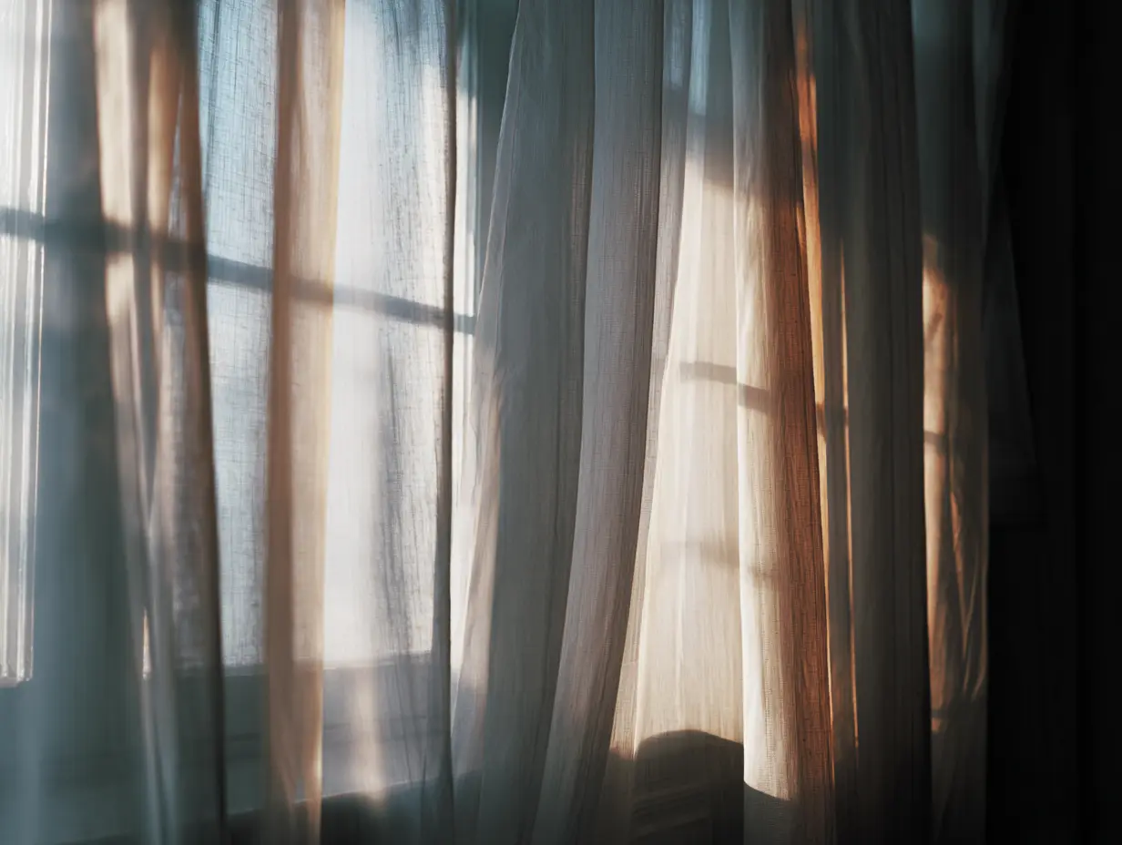 A shot of a window with sheer linen curtains.