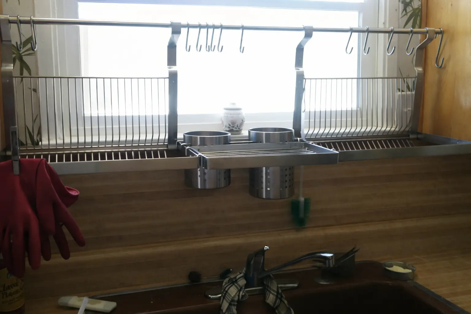An image of a chrome Finnish dish drying rack "astiankuivauskaappi" kept above a sink
