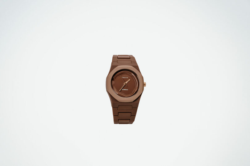 A brown wristwatch with a round face, minimalist design, and metal link band is centered on a plain white background.
