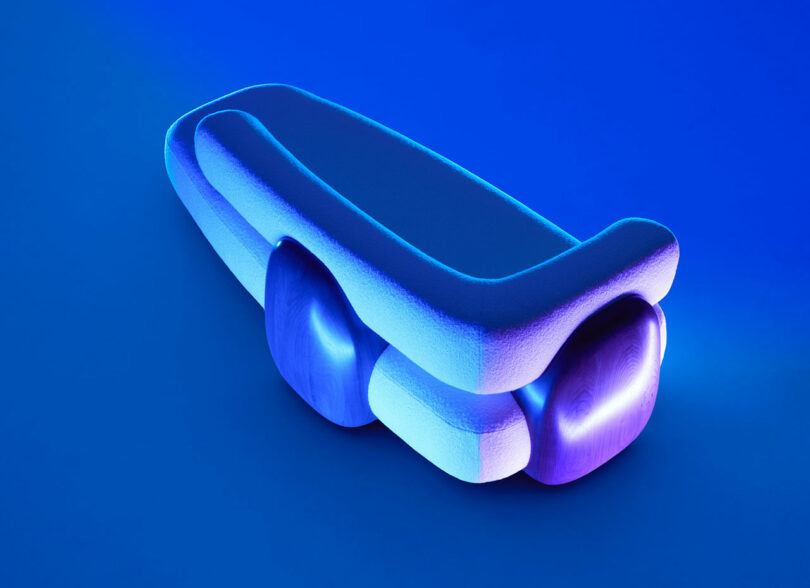 A modern, abstract bench with curved, layered forms and a smooth surface, illuminated by blue and purple lighting against a blue background—a striking piece reminiscent of Holly Hunt's innovative design aesthetic.