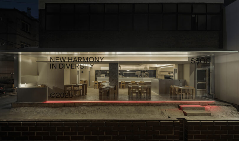 A modern, glass-fronted restaurant with minimalist wooden furniture and the text 