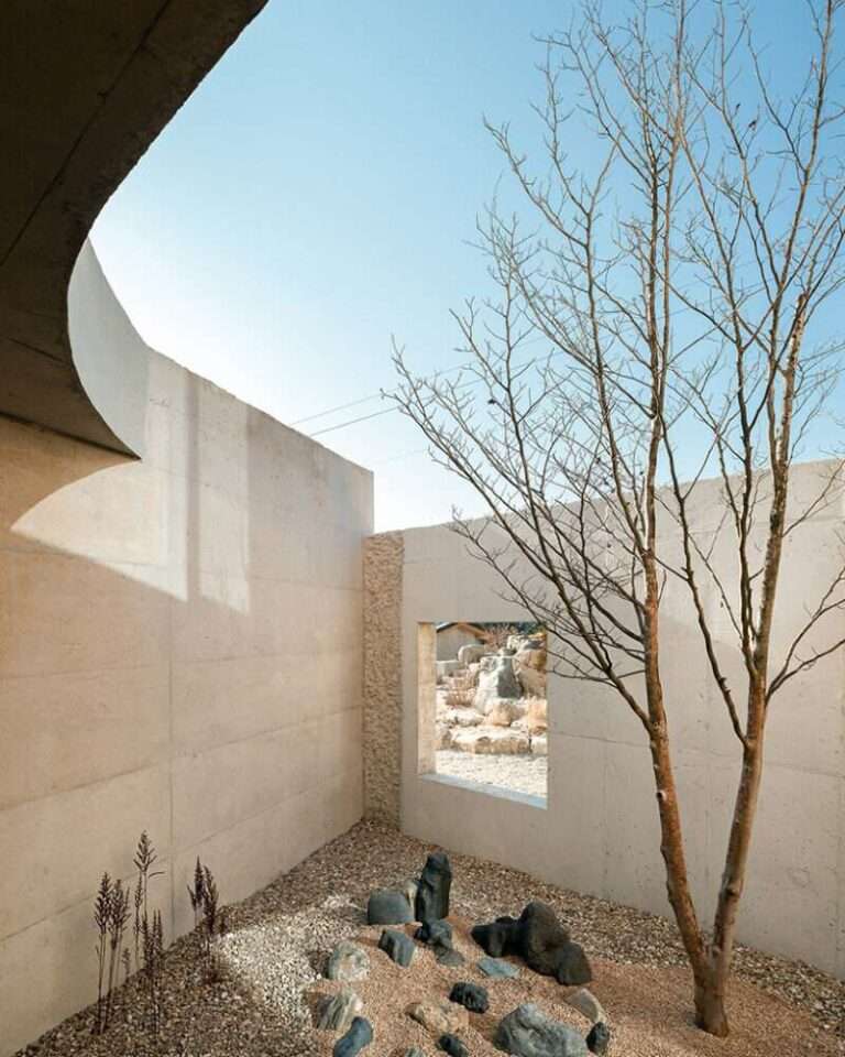 this home in korea is shaped by twin timber gables atop a concrete base