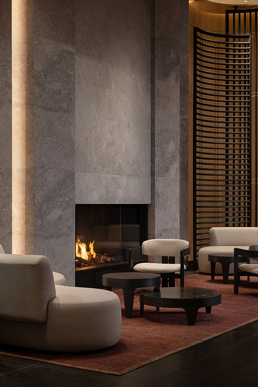 Modern lounge with a lit fireplace, beige sofas, round black tables, and a decorative wooden screen against marble walls.