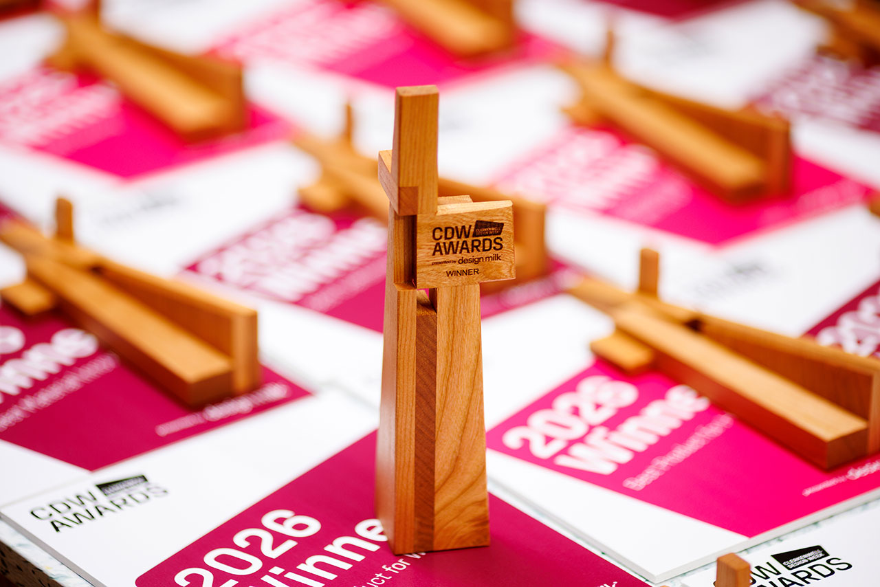 Close-up of a wooden CDW award trophy at Clerkenwell Design Week, placed on a pink and white certificate labeled