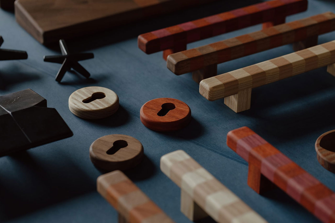 Assorted wooden handles and keyhole-shaped objects in various wood tones arranged on a dark surface.