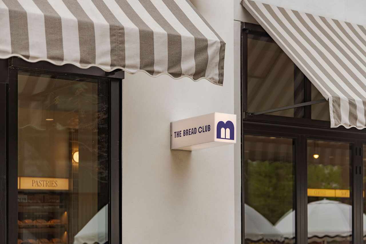 Exterior of a bakery with striped awnings, a sign reading 