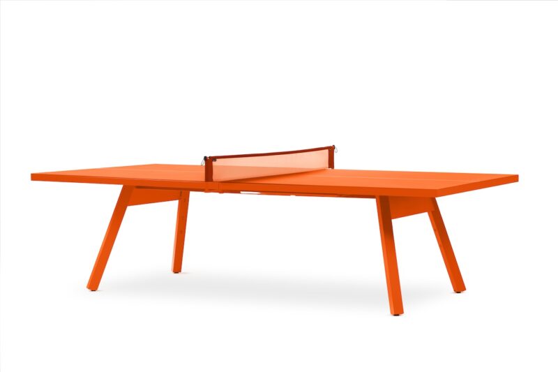 Bright orange ping pong table with an orange net, standing on four angled legs against a white background.