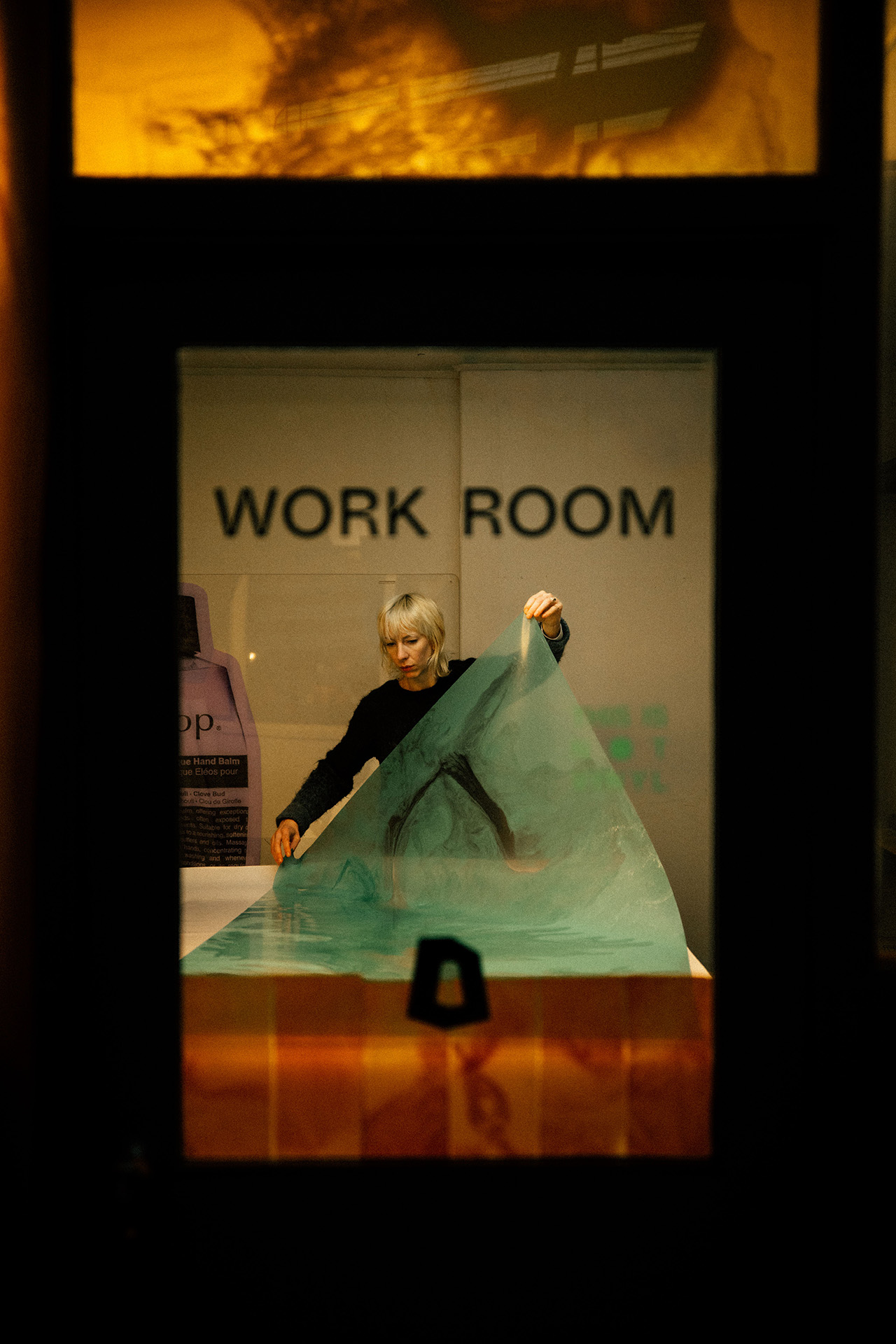 A person with short light hair stands inside a room labeled 