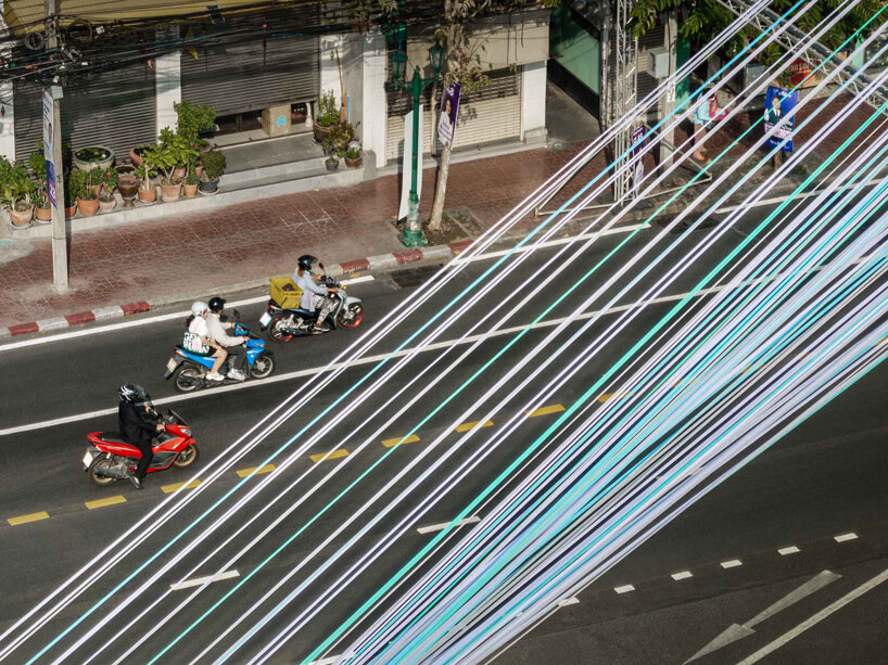 recyclable fabric ribbons weave between bangkok&rsquo;s streetlights into colorful urban canopy - 3