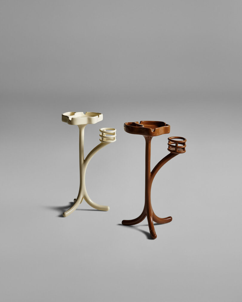 Two modern, three-legged stands in cream and brown colors, each with a circular main tray and a smaller side ring, set against a plain gray background.